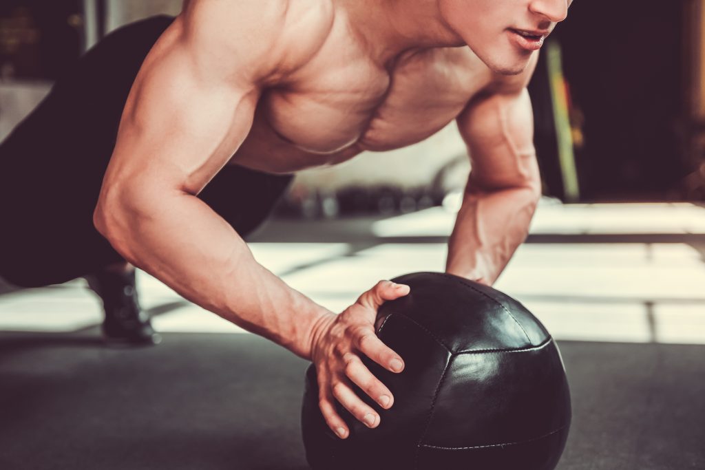 handsome,young,muscular,sportsman,is,working,out,with,a,medicine